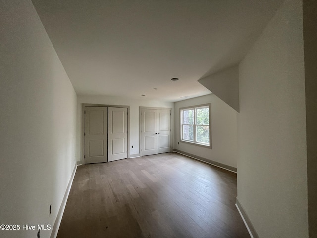 241 Juniper Creek Blvd, Pinehurst, NC 28374 - unfurnished bedroom featuring multiple closets, baseboards, and wood finished floors
