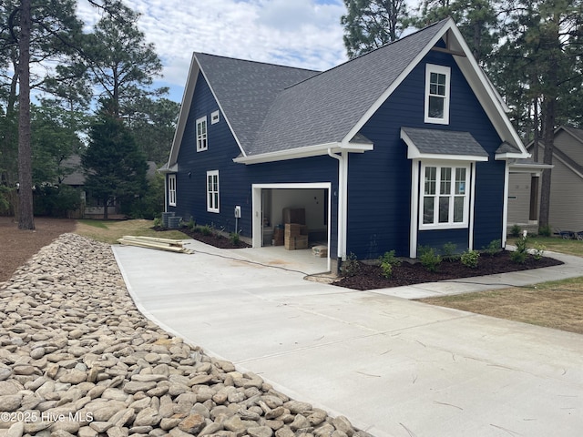 view of home's exterior featuring a shingled roof and driveway