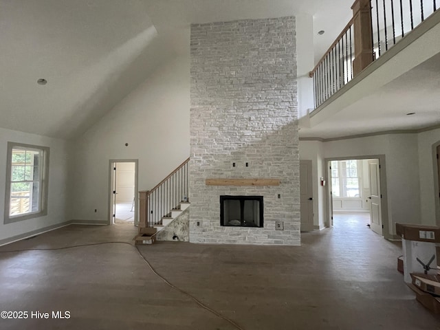241 Juniper Creek Blvd, Pinehurst, NC 28374 - unfurnished living room with high vaulted ceiling, stairway, a large fireplace, and baseboards