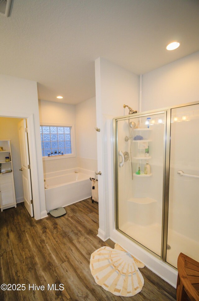 bathroom with hardwood / wood-style flooring and plus walk in shower