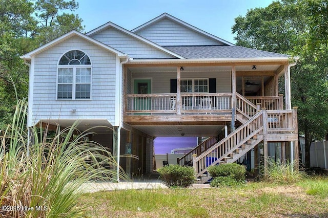 view of front facade featuring ceiling fan, a porch, roof with shingles, stairway, and a carport