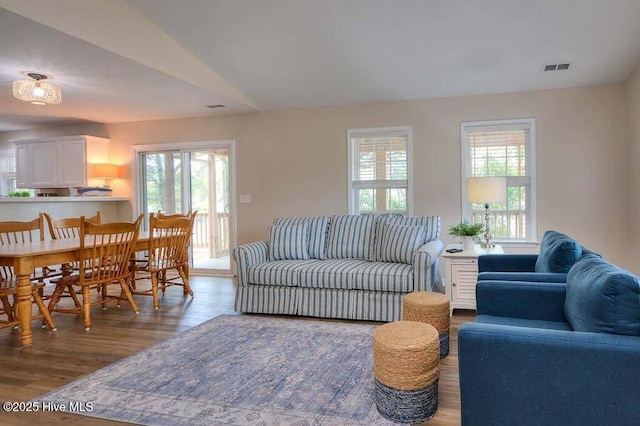 living area featuring visible vents and wood finished floors