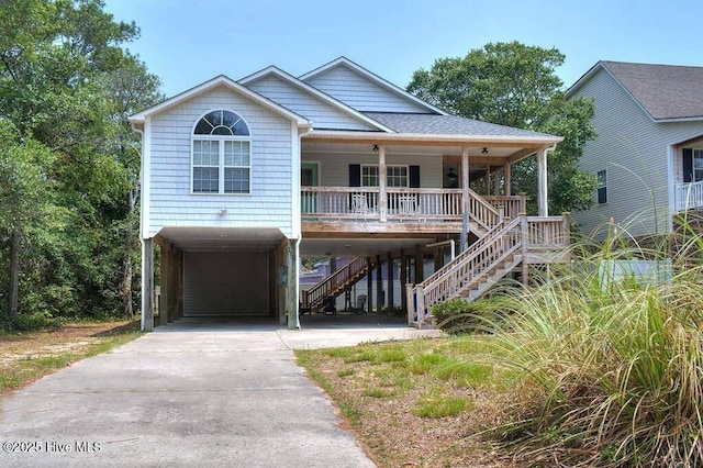 view of front of home featuring driveway, a shingled roof, covered porch, stairs, and a carport