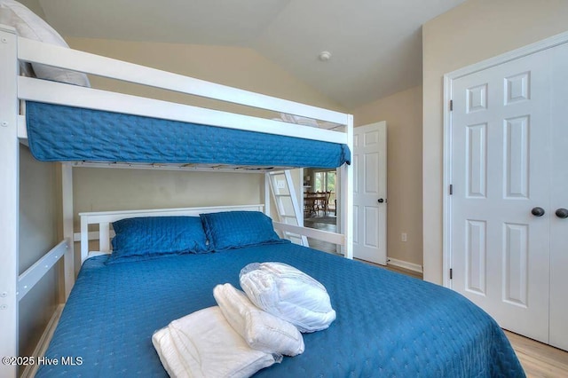 bedroom with lofted ceiling and wood finished floors