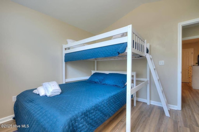 106 NE 62nd St, Oak Island, NC 28465 - bedroom with wood finished floors, vaulted ceiling, and baseboards