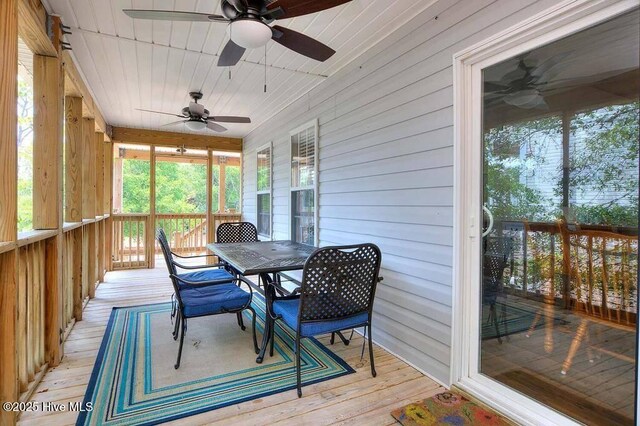 sunroom featuring wood ceiling and a ceiling fan