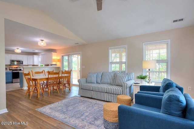 106 NE 62nd St, Oak Island, NC 28465 - living area with healthy amount of natural light, wood finished floors, lofted ceiling, and a ceiling fan