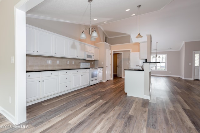 125 Neeley Ln, New Bern, NC 28560 - kitchen with decorative backsplash, lofted ceiling, dark countertops, white appliances, and a notable chandelier