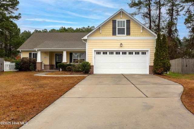 125 Neeley Ln, New Bern, NC 28560 - view of front facade with a porch, brick siding, fence, and concrete driveway