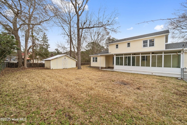 back of property with a shed, a lawn, and a sunroom