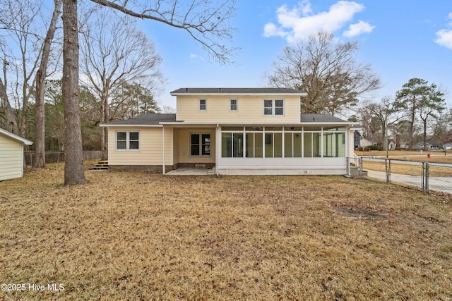 back of property featuring a patio, a sunroom, and a lawn