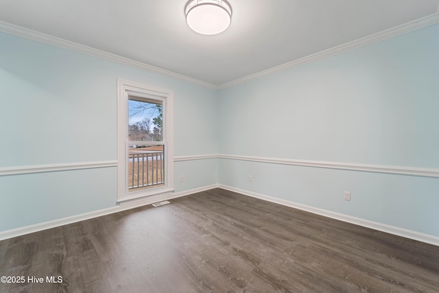 spare room with ornamental molding and dark hardwood / wood-style floors