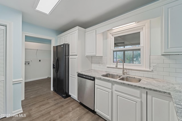 kitchen featuring sink, light hardwood / wood-style floors, white cabinets, black refrigerator with ice dispenser, and stainless steel dishwasher