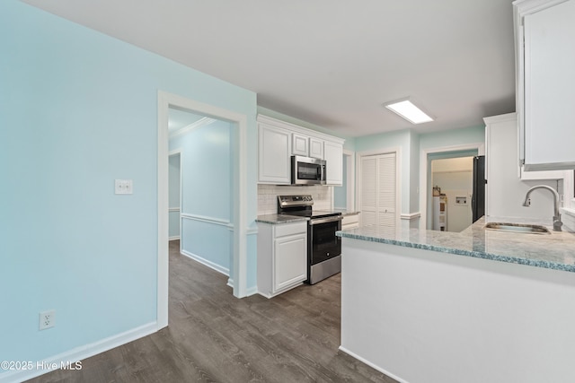 kitchen with hardwood / wood-style floors, sink, white cabinets, decorative backsplash, and stainless steel appliances