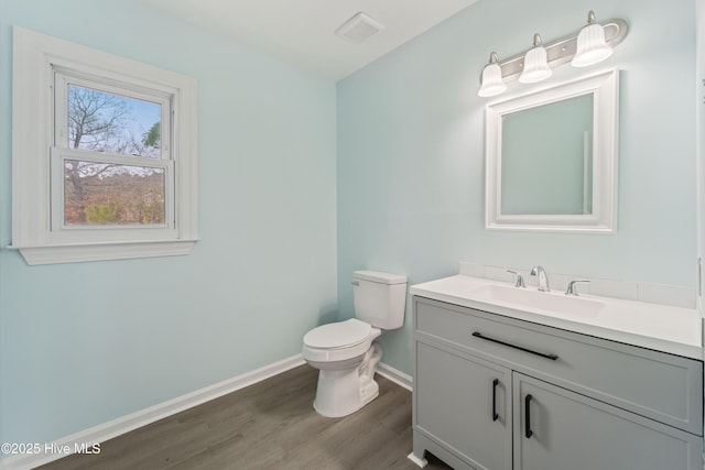 bathroom featuring vanity, hardwood / wood-style floors, and toilet