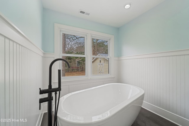 bathroom with hardwood / wood-style floors and a bathtub