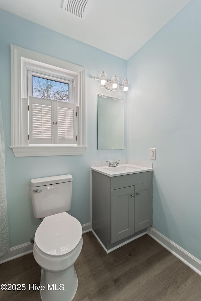 bathroom featuring wood-type flooring, toilet, and vanity