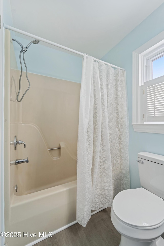 bathroom featuring shower / tub combo with curtain, hardwood / wood-style flooring, and toilet