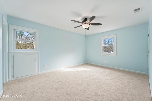 empty room with ceiling fan and light carpet