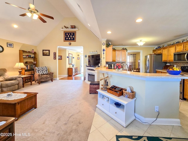 kitchen featuring lofted ceiling, appliances with stainless steel finishes, decorative backsplash, and kitchen peninsula