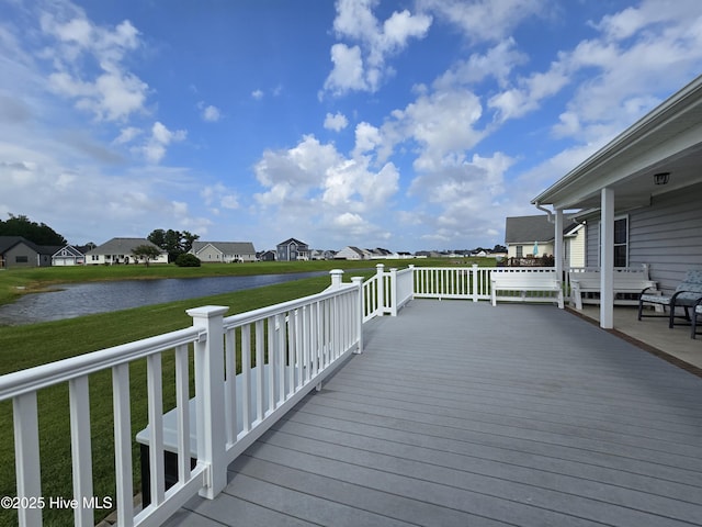 deck with a water view and a yard