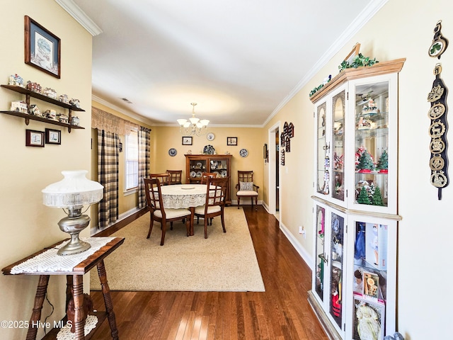 dining area featuring dark hardwood / wood-style flooring, a notable chandelier, and ornamental molding