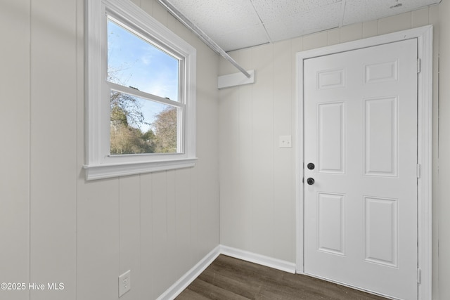 clothes washing area featuring dark wood-style floors and baseboards