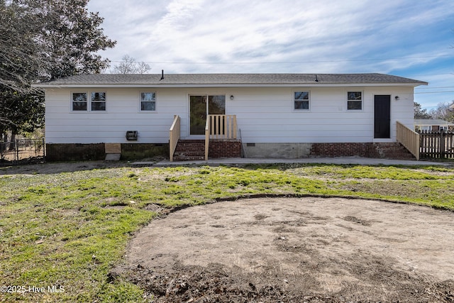 back of property with crawl space, fence, and a yard