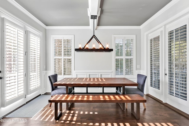 dining room featuring crown molding, wood finished floors, and a wainscoted wall