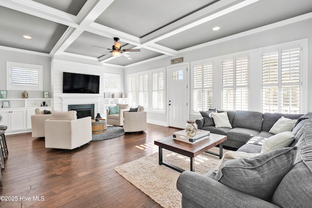 living room featuring dark wood-style flooring, a ceiling fan, plenty of natural light, and coffered ceiling