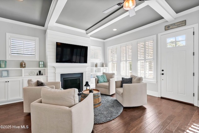 living room featuring dark wood-style flooring, ornamental molding, a fireplace, beamed ceiling, and ceiling fan