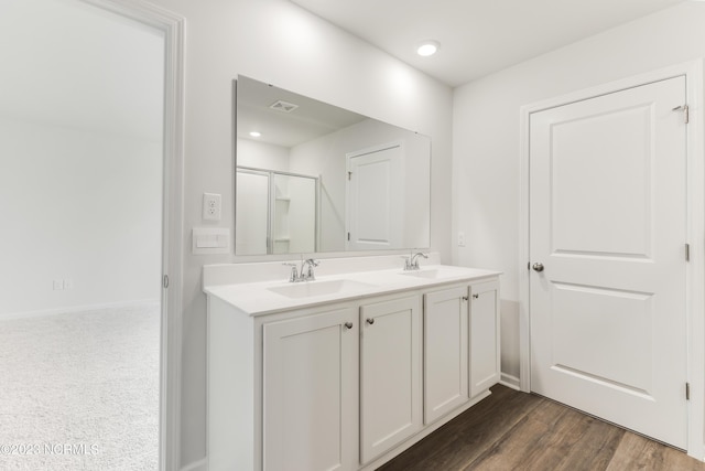 bathroom featuring hardwood / wood-style flooring, vanity, and an enclosed shower