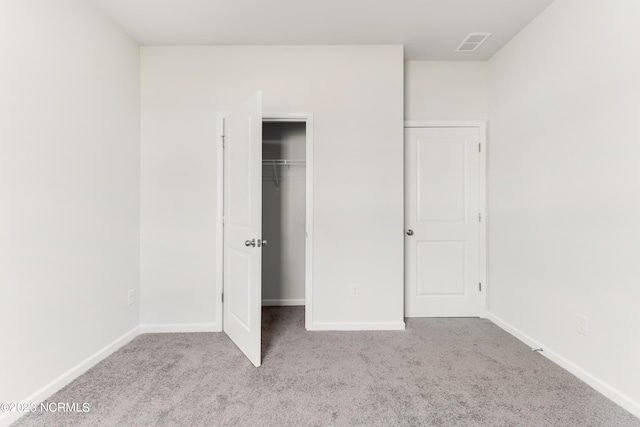 unfurnished bedroom with a closet and light carpet