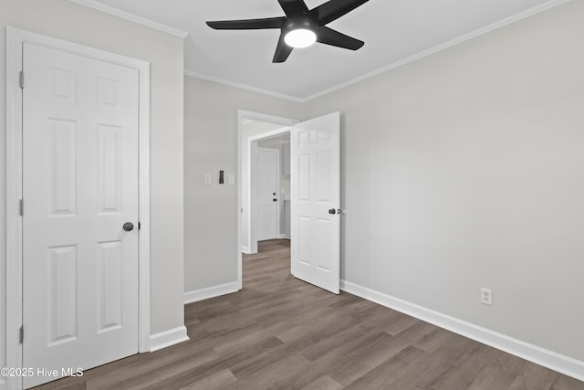 unfurnished bedroom with baseboards, ceiling fan, wood finished floors, and crown molding