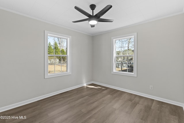 spare room with a ceiling fan, visible vents, baseboards, dark wood finished floors, and crown molding