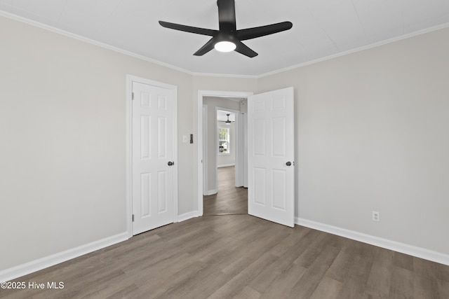 spare room featuring ornamental molding, ceiling fan, baseboards, and wood finished floors