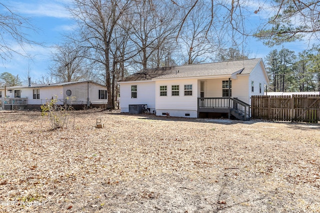 rear view of property featuring central AC unit and fence