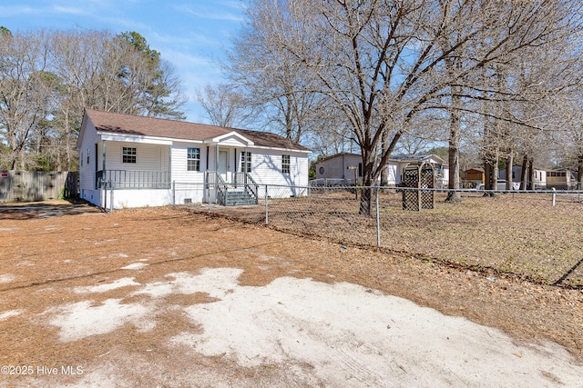 view of front of property featuring crawl space, fence private yard, covered porch, and an outbuilding