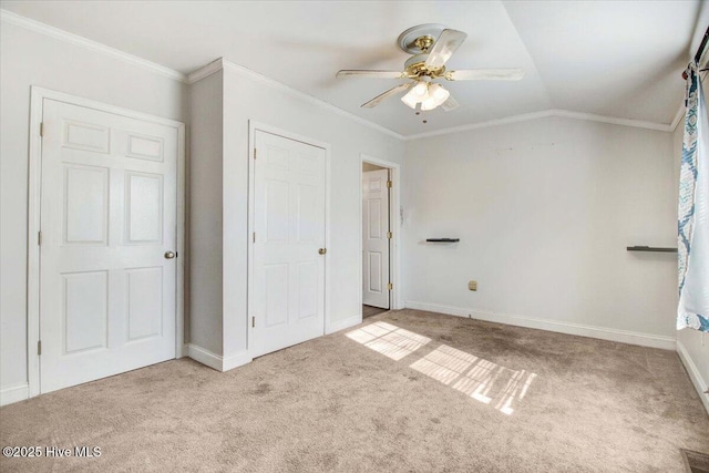 unfurnished bedroom featuring ceiling fan, light colored carpet, ornamental molding, and lofted ceiling