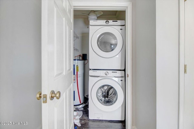 laundry room featuring water heater and stacked washer / dryer