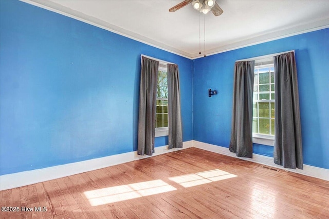 empty room with hardwood / wood-style floors, a wealth of natural light, and ceiling fan