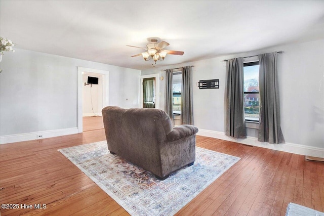 living room with ceiling fan and light wood-type flooring