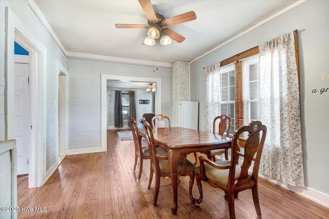 dining room featuring crown molding, ceiling fan, and light wood-type flooring