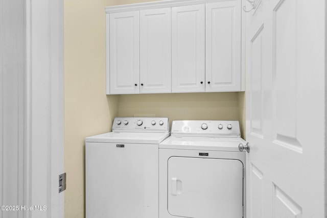 washroom featuring cabinets and washing machine and clothes dryer