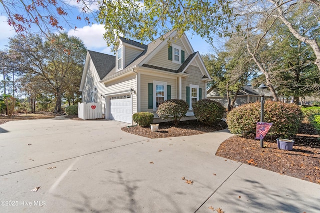 view of front facade with a shingled roof, concrete driveway, and an attached garage