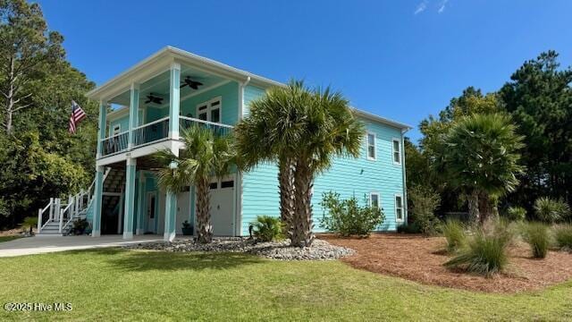 view of front of property with ceiling fan, a front yard, and stairs