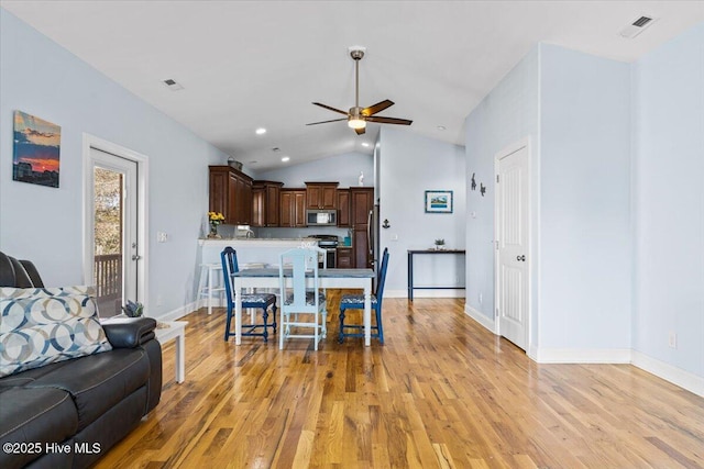 interior space featuring light wood finished floors, visible vents, baseboards, lofted ceiling, and a ceiling fan