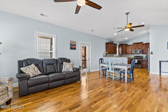 living room featuring visible vents, baseboards, light wood-type flooring, and ceiling fan