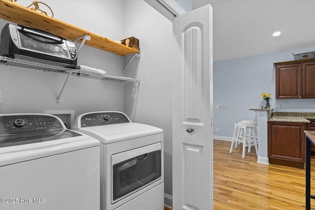 washroom featuring baseboards, laundry area, recessed lighting, washing machine and dryer, and light wood-type flooring