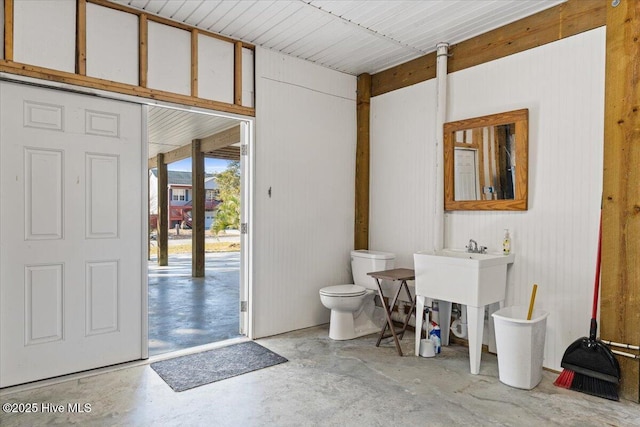 134 NE 11th St, Oak Island, NC 28465 - half bath featuring concrete flooring, toilet, and wooden walls